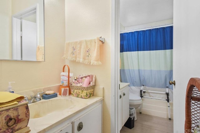 full bath featuring toilet, curtained shower, wood finished floors, and vanity