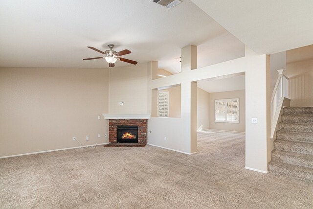 unfurnished living room with ceiling fan, light colored carpet, a fireplace, and vaulted ceiling