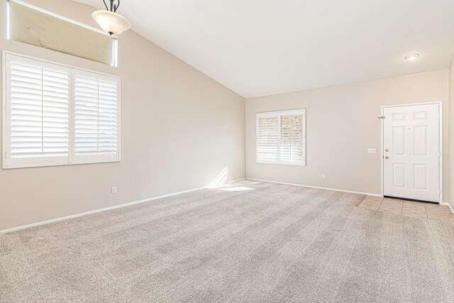 unfurnished room with light carpet and vaulted ceiling