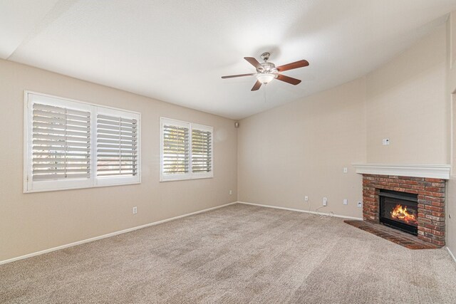 unfurnished living room with light colored carpet, a brick fireplace, and ceiling fan