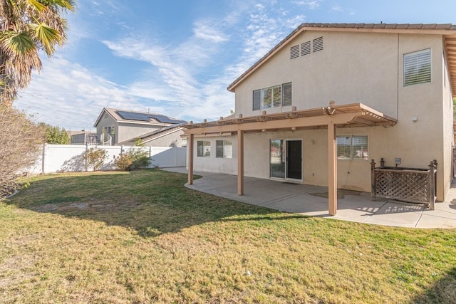 back of house featuring a lawn and a patio