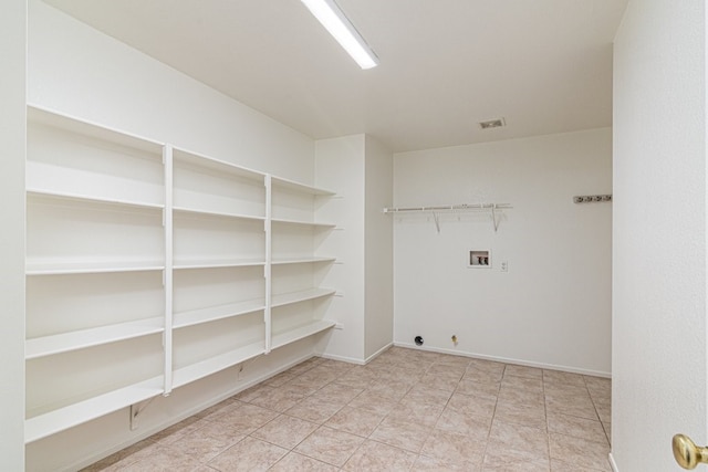 clothes washing area with hookup for a gas dryer, hookup for a washing machine, and light tile patterned flooring