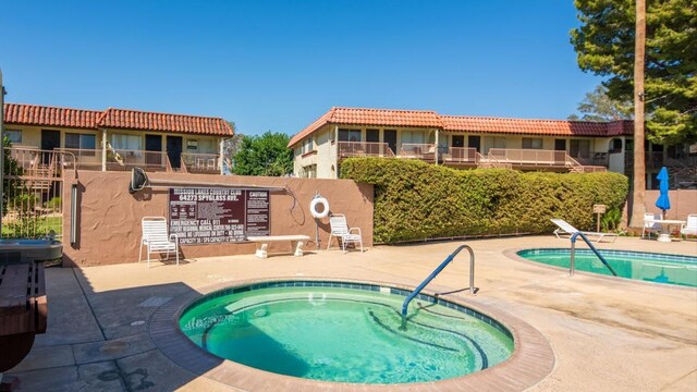 view of swimming pool with a patio and a hot tub