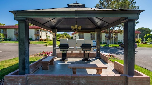 surrounding community with a gazebo and an outdoor kitchen