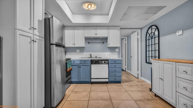 kitchen featuring sink, light tile patterned floors, blue cabinetry, white cabinetry, and stainless steel appliances