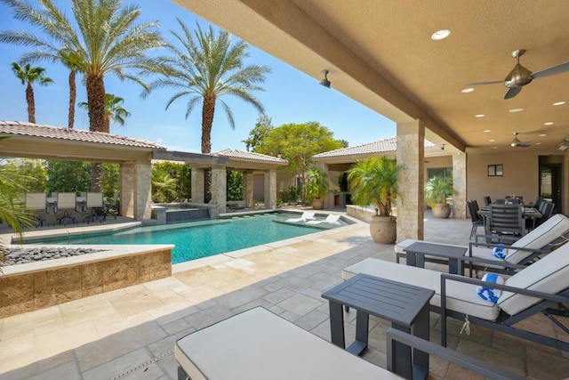 view of swimming pool featuring an in ground hot tub, a patio, and ceiling fan