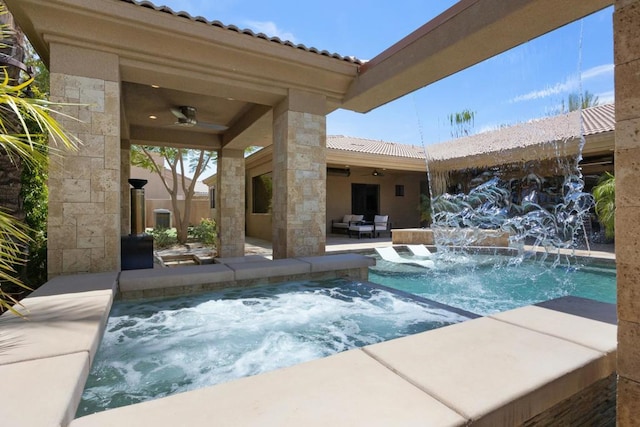 view of pool with an in ground hot tub, pool water feature, ceiling fan, and a patio area