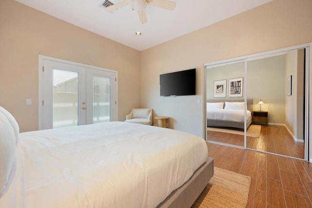 bedroom with a closet, ceiling fan, french doors, and hardwood / wood-style flooring