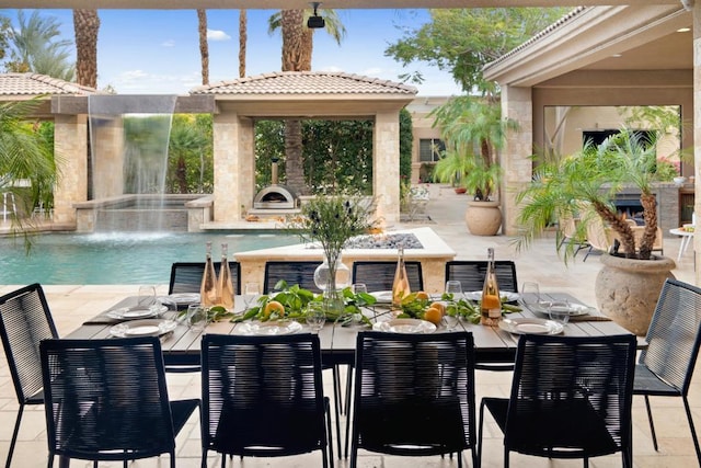 view of swimming pool featuring pool water feature, a patio, a jacuzzi, and an outdoor fireplace