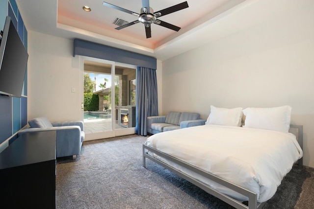 bedroom with a raised ceiling, access to exterior, ceiling fan, and carpet flooring