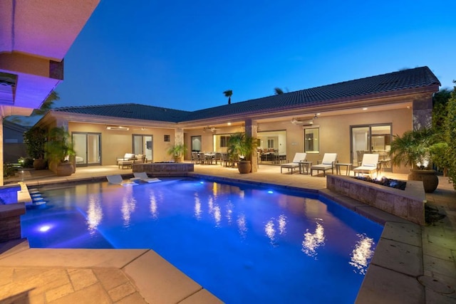 view of pool featuring ceiling fan, a patio area, and an outdoor living space with a fire pit