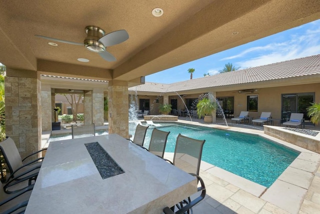 view of pool featuring an outdoor bar, pool water feature, a patio, and ceiling fan