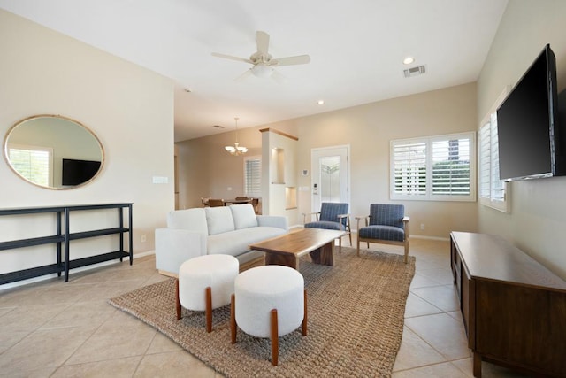 living room with ceiling fan with notable chandelier and light tile patterned flooring