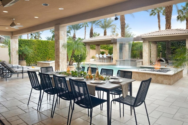 view of patio / terrace featuring pool water feature, ceiling fan, and a swimming pool with hot tub