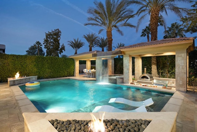 view of pool featuring a jacuzzi, a patio, and a fire pit