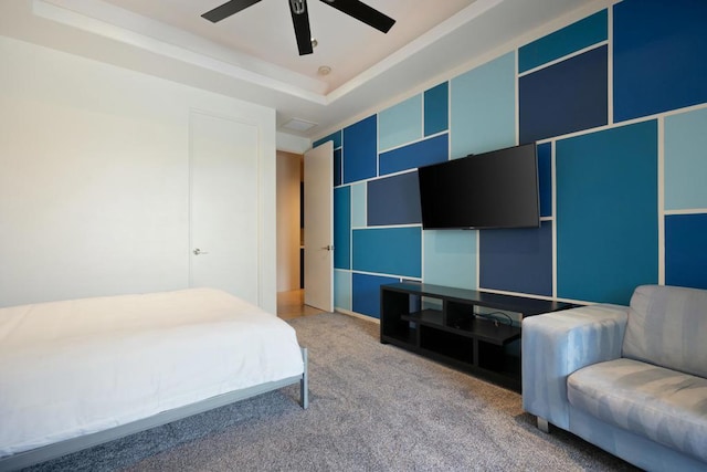 bedroom featuring carpet flooring, ceiling fan, and a tray ceiling