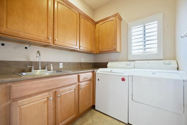 laundry area featuring light tile patterned flooring, cabinets, separate washer and dryer, and sink