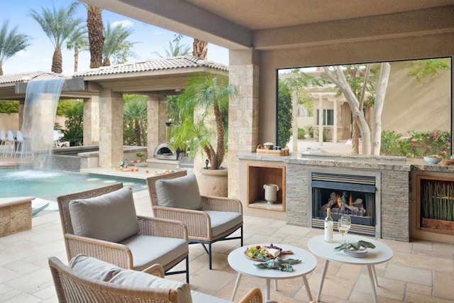 view of patio with an outdoor stone fireplace and pool water feature