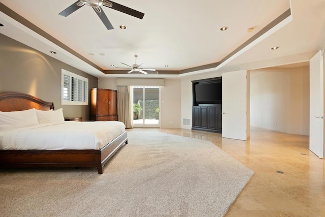 bedroom featuring a tray ceiling, ceiling fan, and access to outside