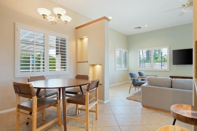 tiled dining space featuring ceiling fan with notable chandelier