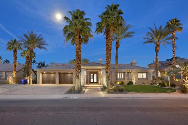 view of front of home with a yard and a garage