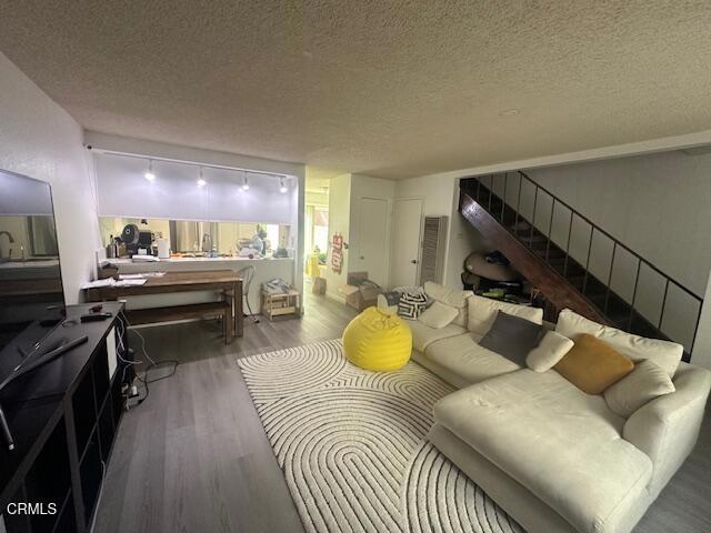 living room featuring wood-type flooring and a textured ceiling