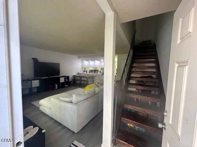 staircase with wood-type flooring and a textured ceiling