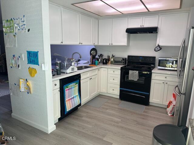 kitchen with white cabinetry, sink, black appliances, and light hardwood / wood-style floors