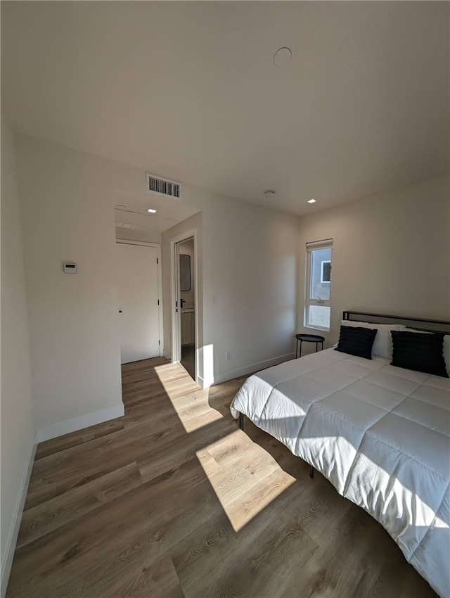 bedroom with dark hardwood / wood-style flooring