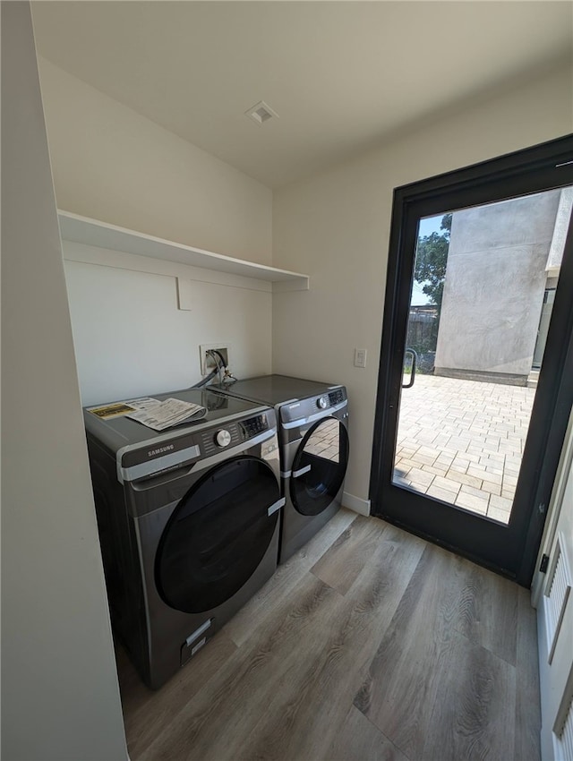 laundry room with hardwood / wood-style floors and washing machine and clothes dryer