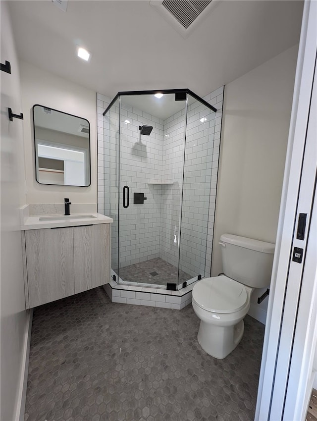 bathroom with a shower with door, vanity, and toilet