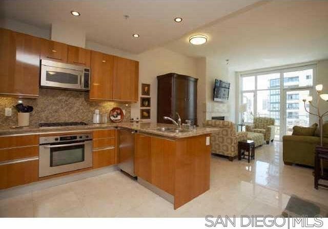 kitchen with kitchen peninsula, appliances with stainless steel finishes, backsplash, and sink