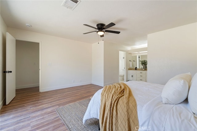 bedroom with ensuite bath, ceiling fan, and light hardwood / wood-style floors