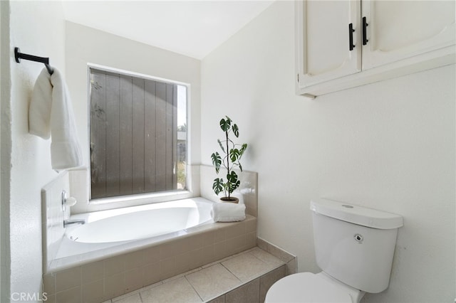 bathroom featuring tiled bath, lofted ceiling, and toilet