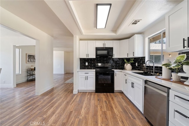 kitchen featuring sink, white cabinets, and black appliances