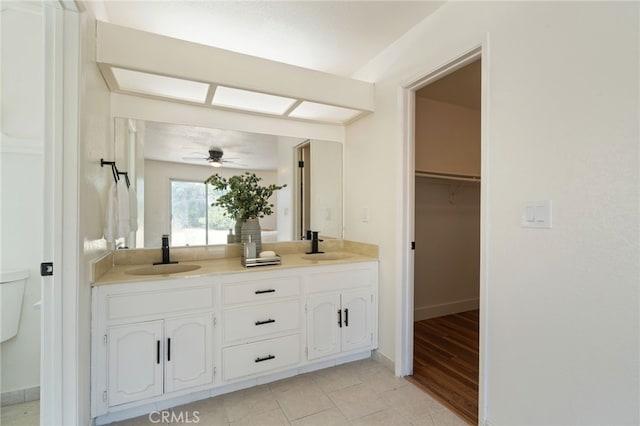 bathroom featuring ceiling fan, toilet, vanity, and hardwood / wood-style flooring