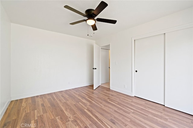 unfurnished bedroom featuring ceiling fan, a closet, and light hardwood / wood-style flooring