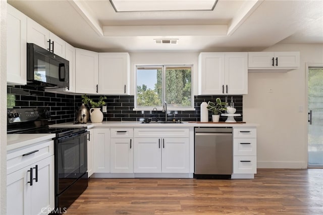 kitchen with white cabinets, black appliances, and dark hardwood / wood-style floors