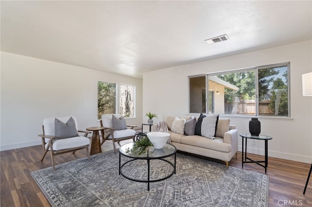 living room featuring dark wood-type flooring and a textured ceiling