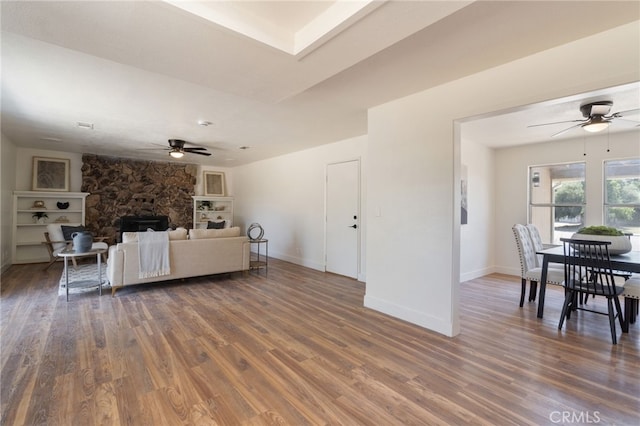 living room with ceiling fan and dark wood-type flooring