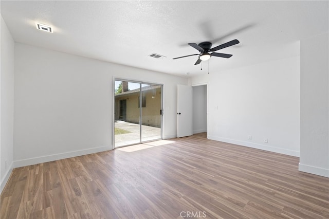 spare room featuring ceiling fan, wood-type flooring, and a textured ceiling