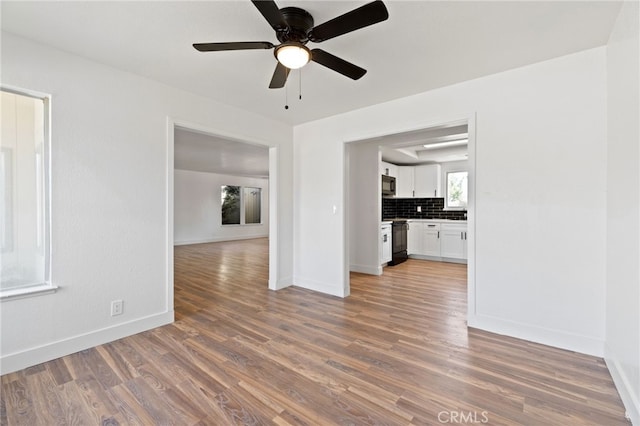 unfurnished living room with ceiling fan and dark hardwood / wood-style floors