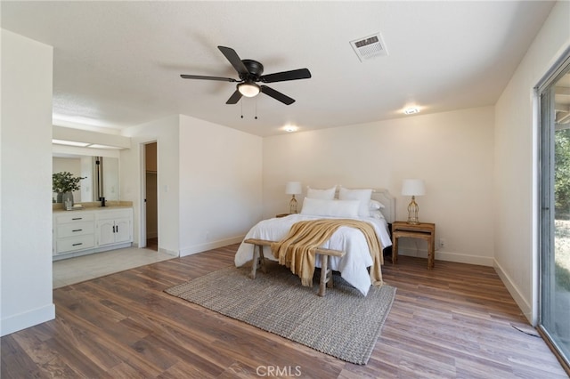 bedroom with connected bathroom, ceiling fan, and light hardwood / wood-style flooring