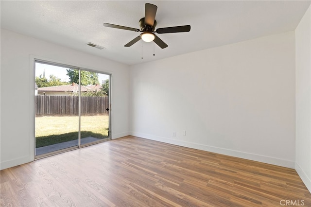 spare room featuring ceiling fan, wood-type flooring, and a textured ceiling