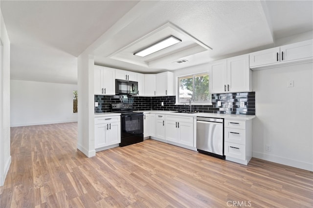 kitchen featuring sink, light hardwood / wood-style flooring, white cabinetry, and black appliances