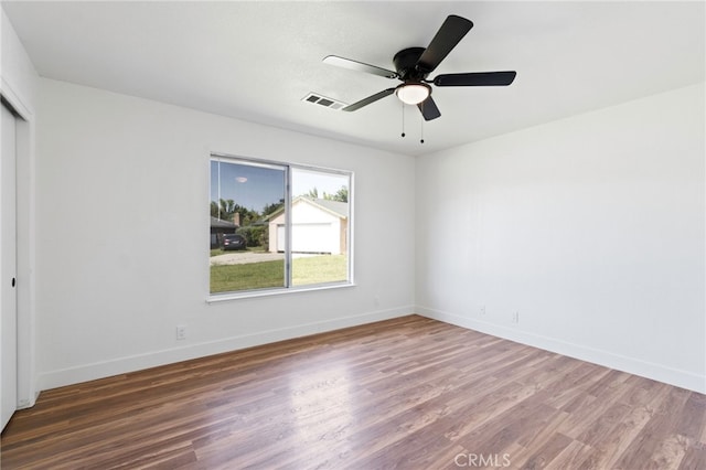 unfurnished bedroom featuring a closet, dark hardwood / wood-style floors, and ceiling fan