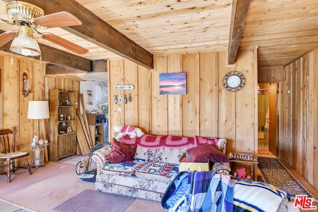 bedroom with beam ceiling, wood walls, carpet, and wood ceiling