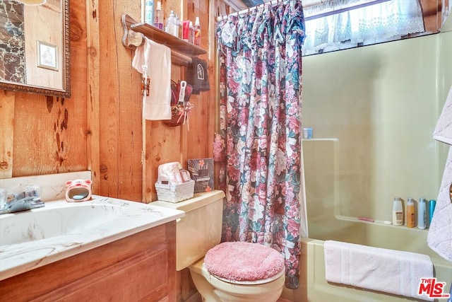 full bathroom featuring shower / tub combo, vanity, toilet, and wooden walls