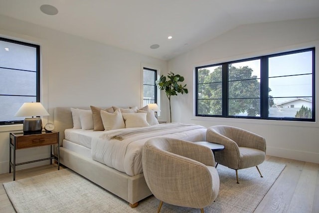 bedroom with light hardwood / wood-style floors and vaulted ceiling