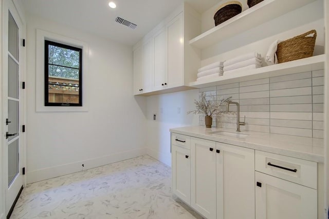 laundry room featuring sink and cabinets